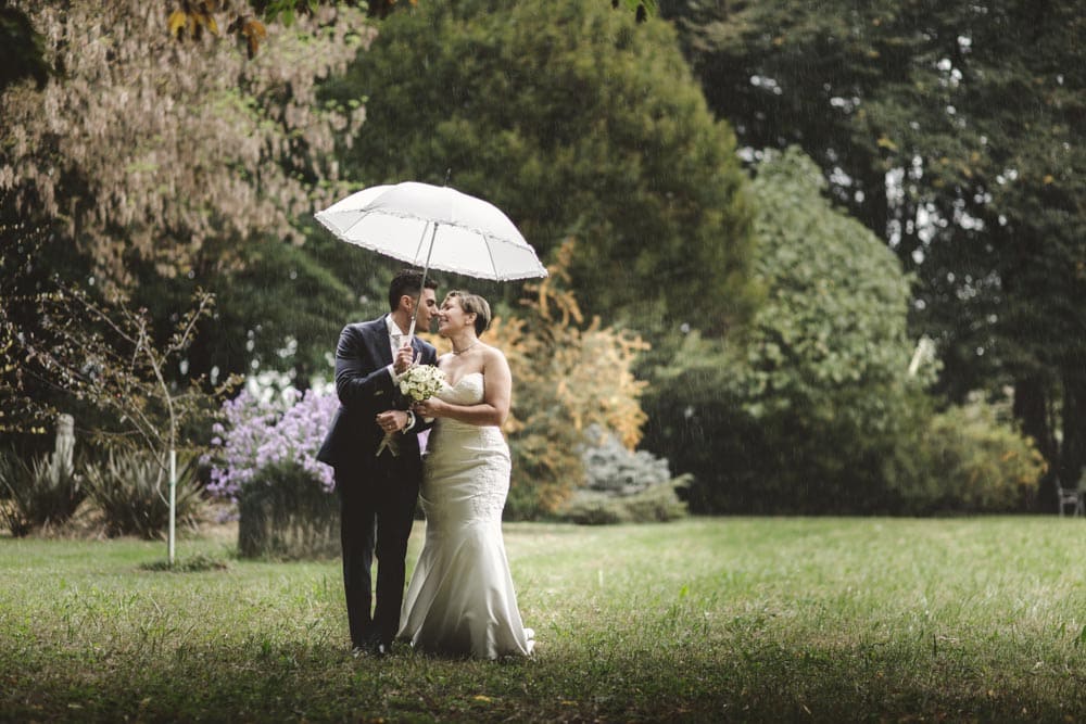 Immagine di sposi in parco Ca marcello con ombrello tempo piovoso