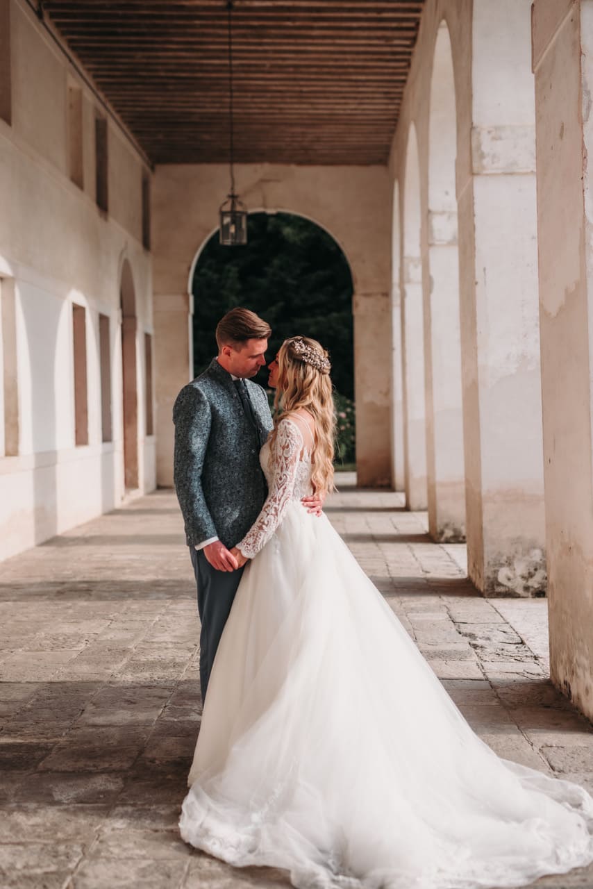 Sposi sotto il porticato che si guardano illuminati da una luce lieve